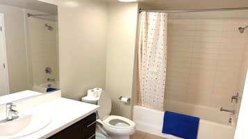 A bathroom with a toilet, sink, and bathtub.
