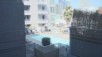 A pool area with lounge chairs and a view of high-rise buildings.