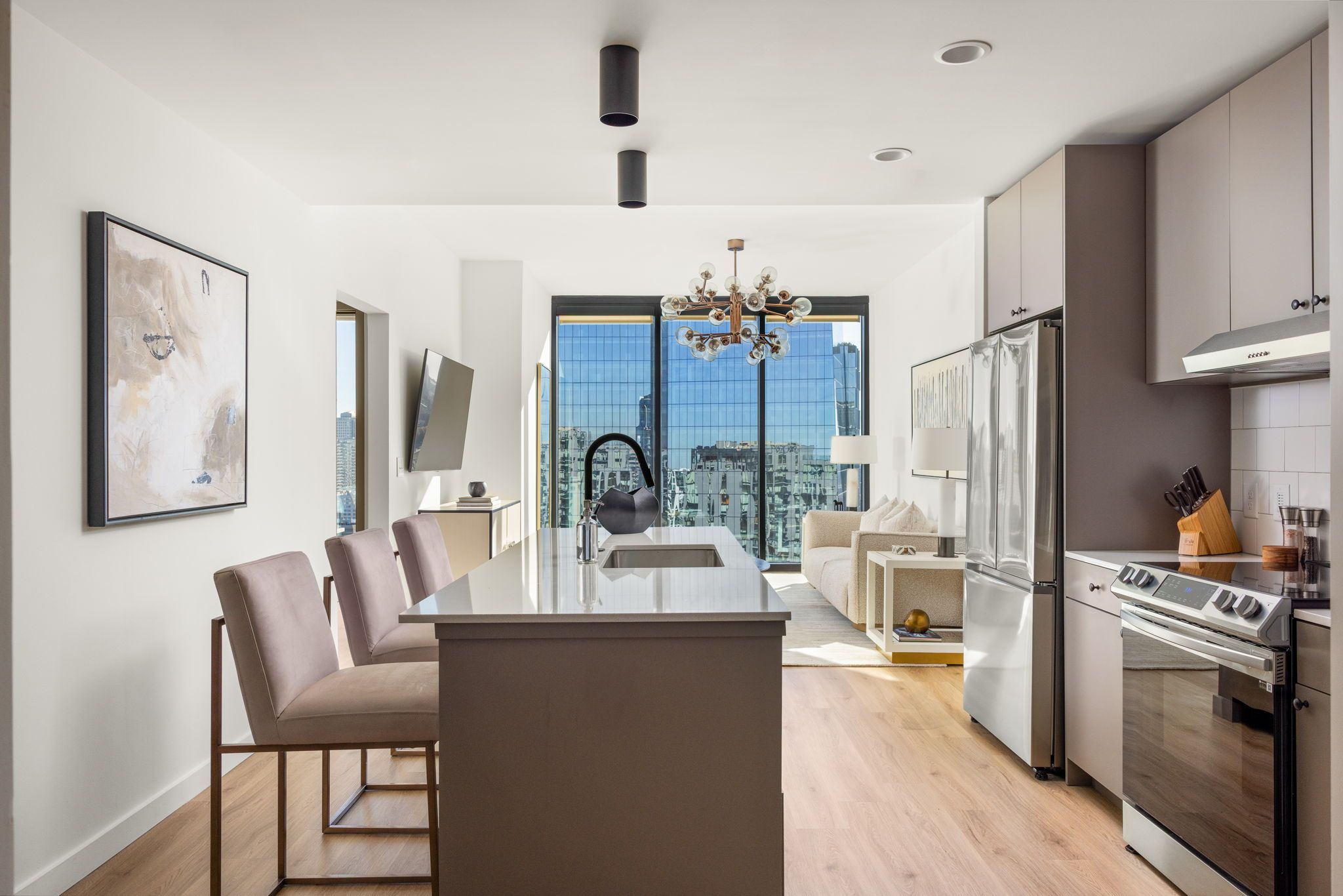 A modern kitchen with a central island, built-in appliances, and a view of the city.