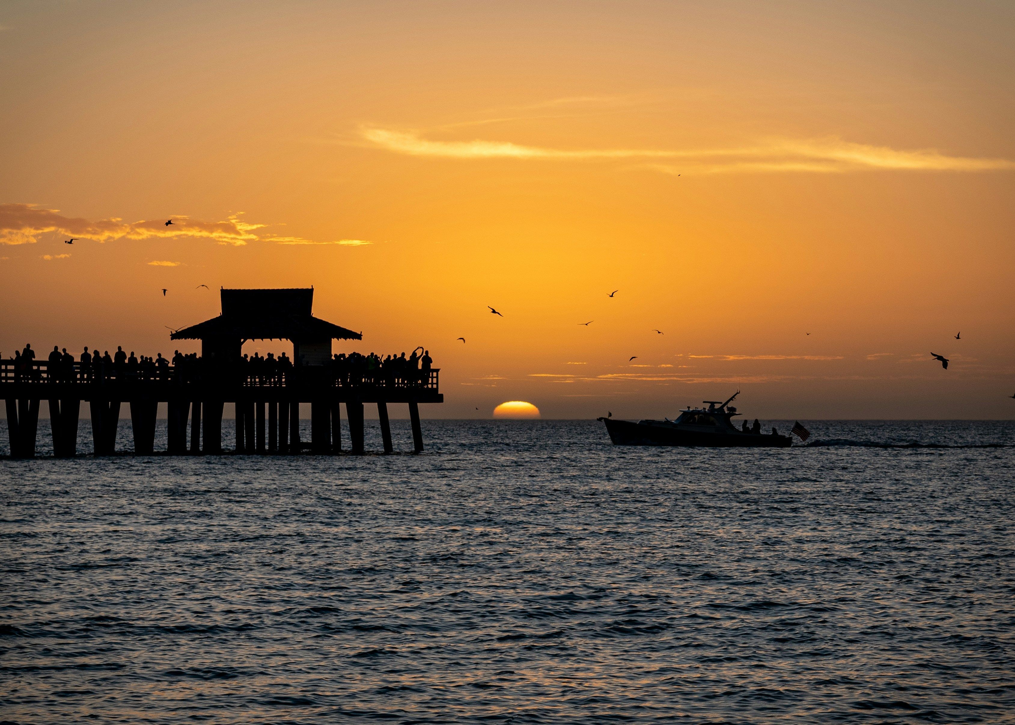 A pier with a viewing platform and a boat in the water.