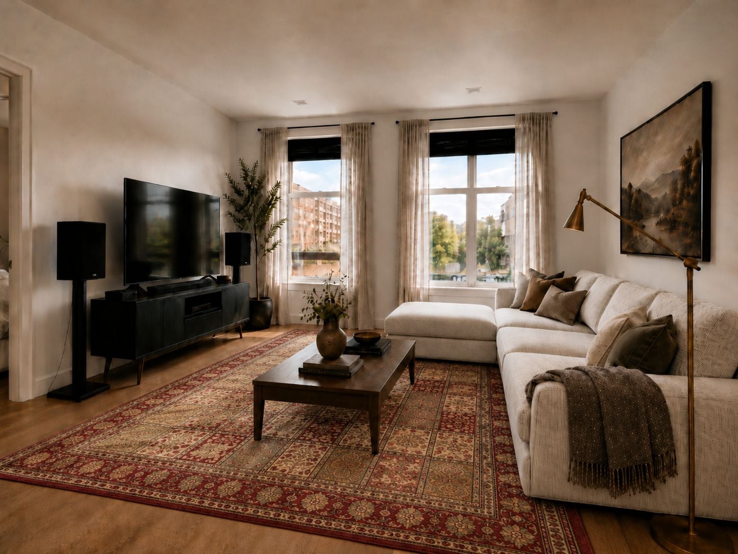 A living room with a sofa, a coffee table, a TV, and a large window with curtains.