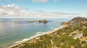 Une zone résidentielle côtière avec une plage, des maisons et une colline boisée.