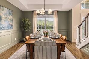 A dining room with a wooden table set for six, a chandelier, and a large window with curtains. - Private Estate • Hot Tub • Sauna • Game Room • Theater • Gym • Saloon • Mtn View (Trenton)