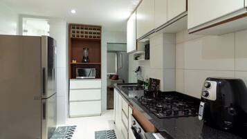 Una cocina moderna con electrodomésticos de acero inoxidable, un microondas integrado y una estufa a gas.