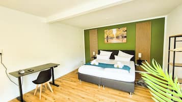 Une chambre à coucher avec un lit, un bureau et un mur vert.