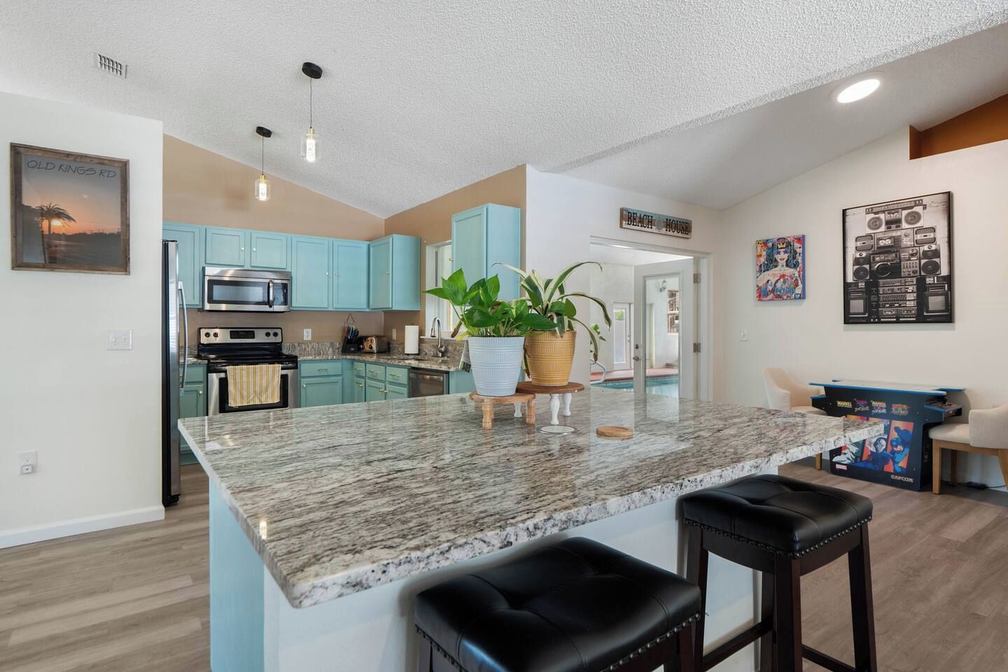 A modern kitchen with granite countertops, a central island, and light blue cabinets.