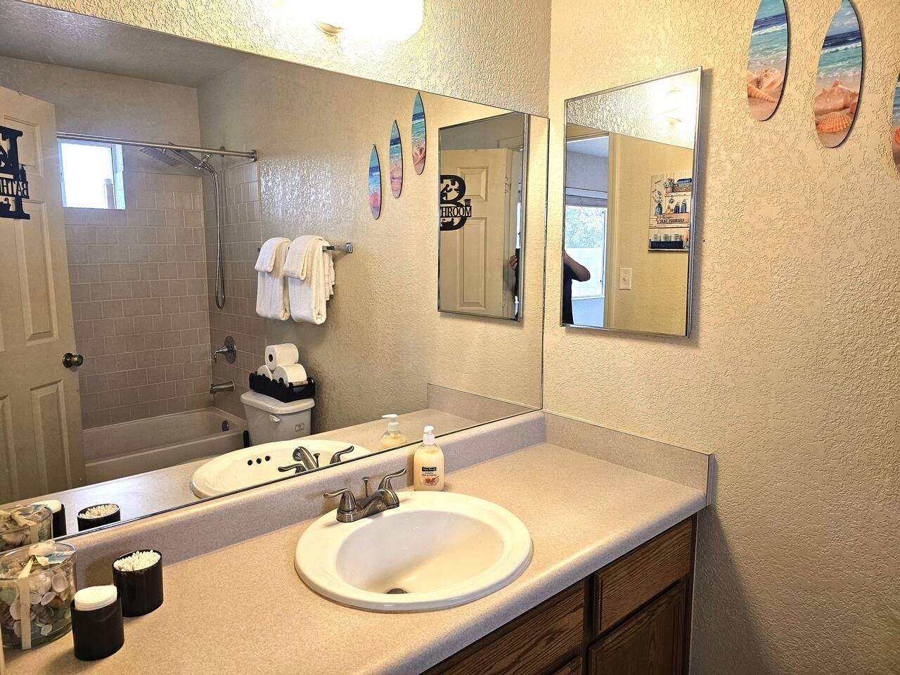 Un baño con un espejo grande, un lavamanos y una ducha.