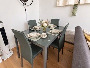 A dining table set with plates, cups, and a vase of flowers. - Stylish 2-Bed Apartment -Canary Wharf - Sleeps 5- Near City Airport & Westfields (London)