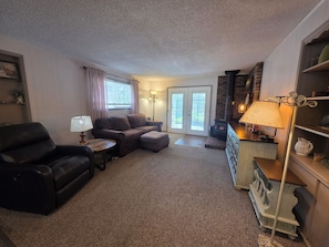 A living room with a sofa, armchair, and ottoman, a fireplace, and a lamp. - Coming to town for a weekend of games? 3Br/2Ba home - pet friendly w/ RV Parking (Selah)