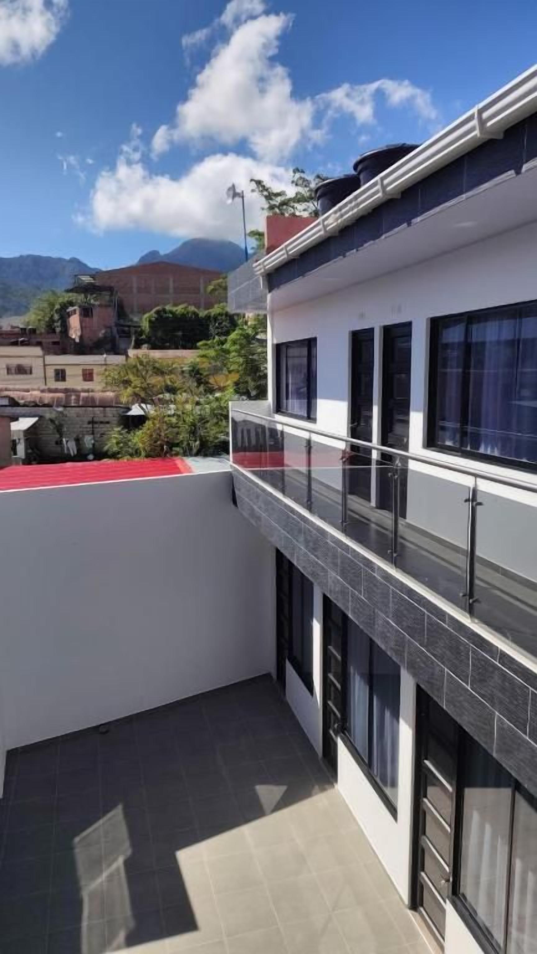 Un bâtiment doté d’un balcon, d’un tapis rouge et offrant une vue sur les montagnes.