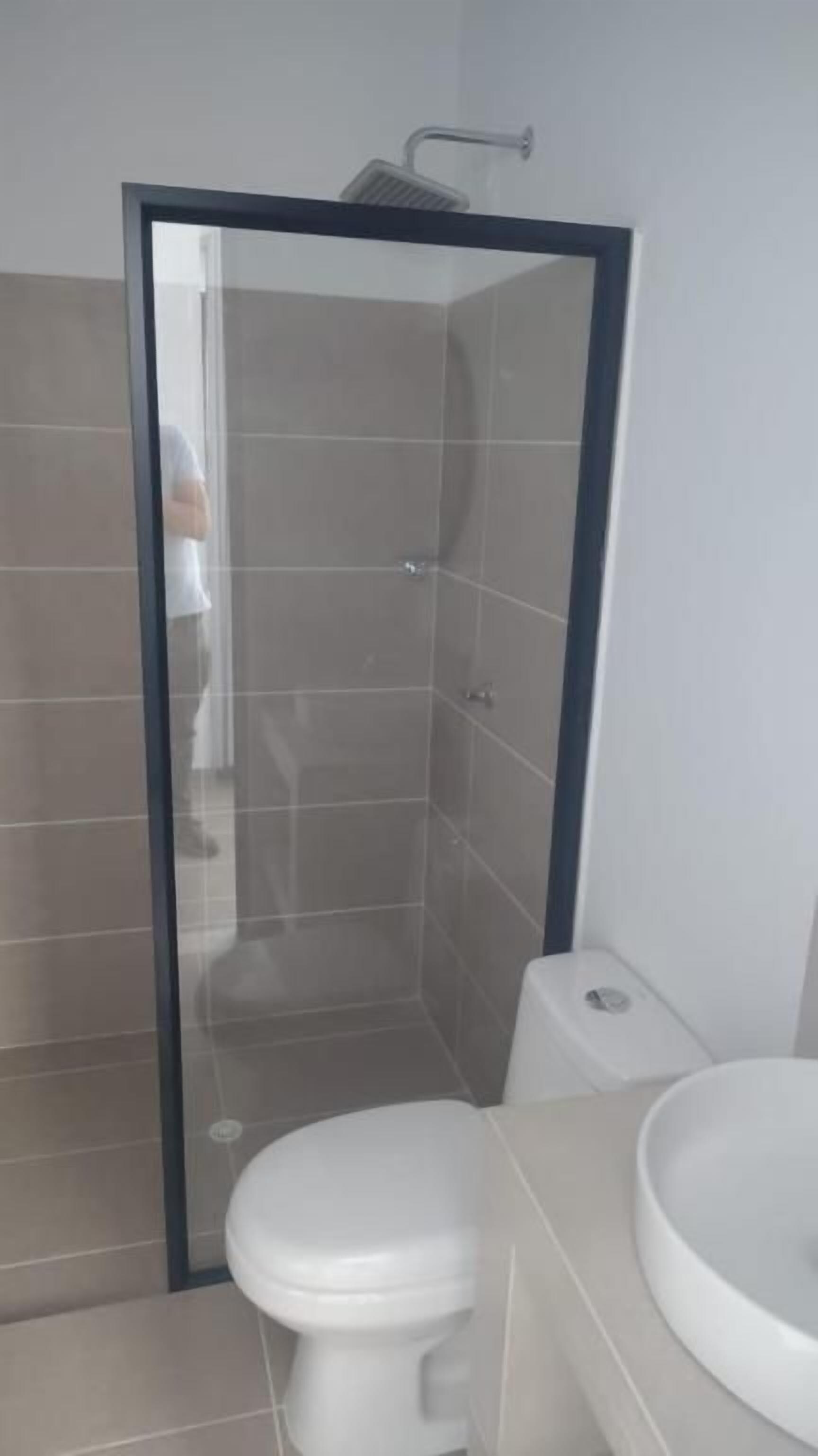 Un baño con ducha de vidrio, inodoro y lavamanos.