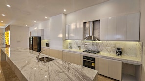 Una cocina moderna con encimeras de mármol, electrodomésticos de acero inoxidable y un diseño elegante.