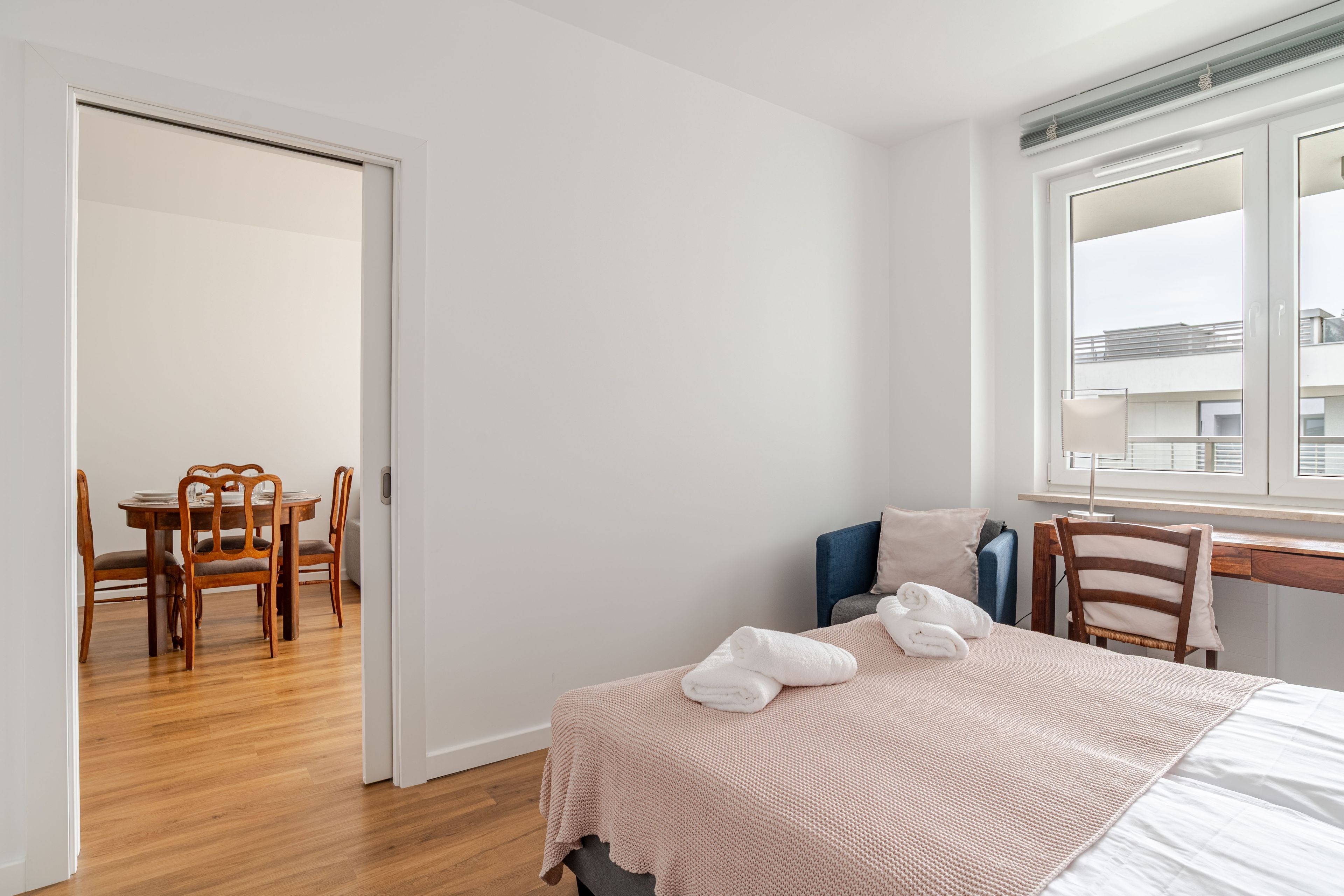 Ein Hotelzimmer mit Bett, Schreibtisch, Stuhl und Esstisch.