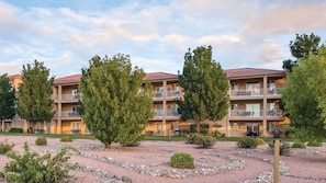 A multi-story residential building with balconies, surrounded by trees and a gravel pathway. - WorldMark St. George 2BR Twin - Red Rock Base Camp for Zion & Snow Canyon (St. George)