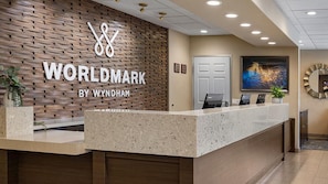 Un mostrador de recepción con un panel de madera y un letrero que dice 'WORLDMARK BY WYNDHAM'.