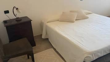 Una camera da letto con un letto, una scrivania, una sedia e una finestra.