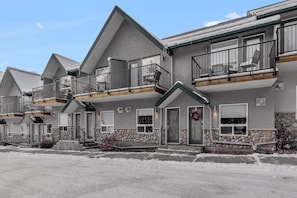 A multi-story hotel with balconies, stone accents, and a clear sky. - B243- Cozy 2-bedroom townhome in wonderful Harvie Heights with AC (Harvie Heights)
