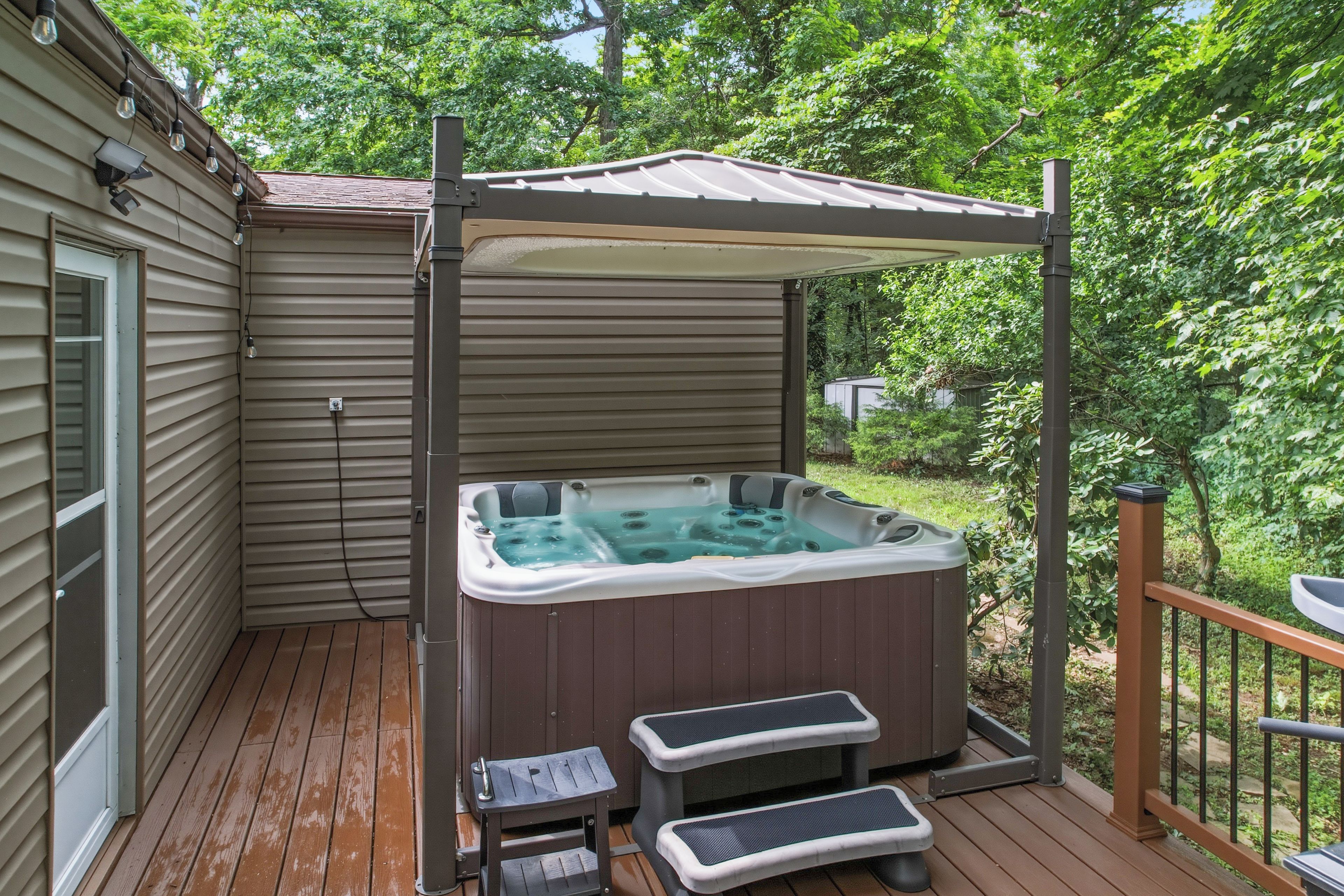 A hot tub on a wooden deck with a pergola overhead.