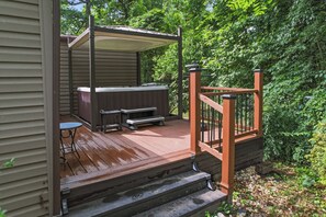 Eine Holzterrasse mit Whirlpool, Tisch und Bänken.