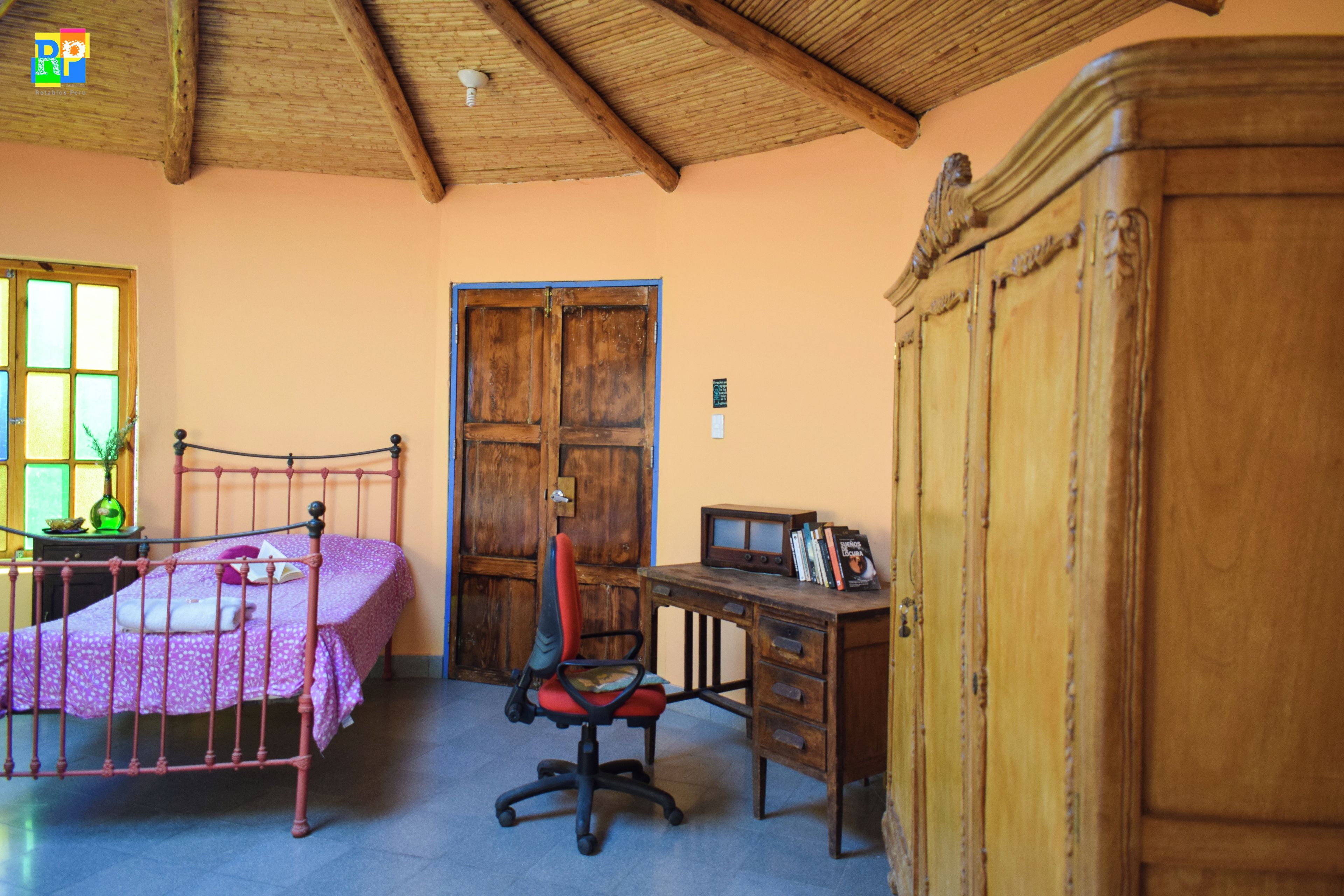 Una habitación con cama, escritorio, silla y armario.