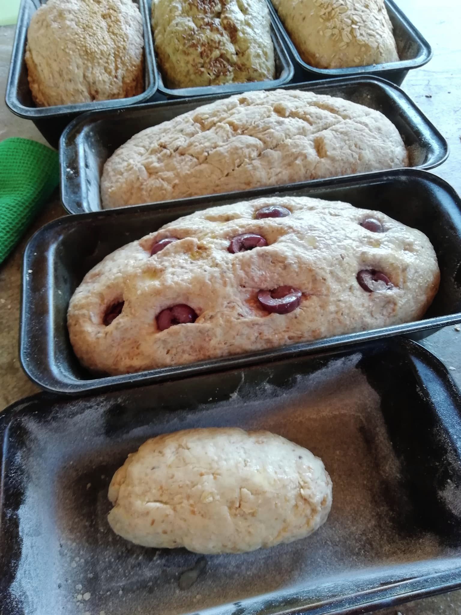 A tray with various baked goods, including a loaf with cherries and a smaller round item.