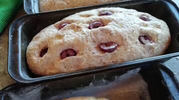 A tray with various baked goods, including a loaf with cherries and a smaller round item.