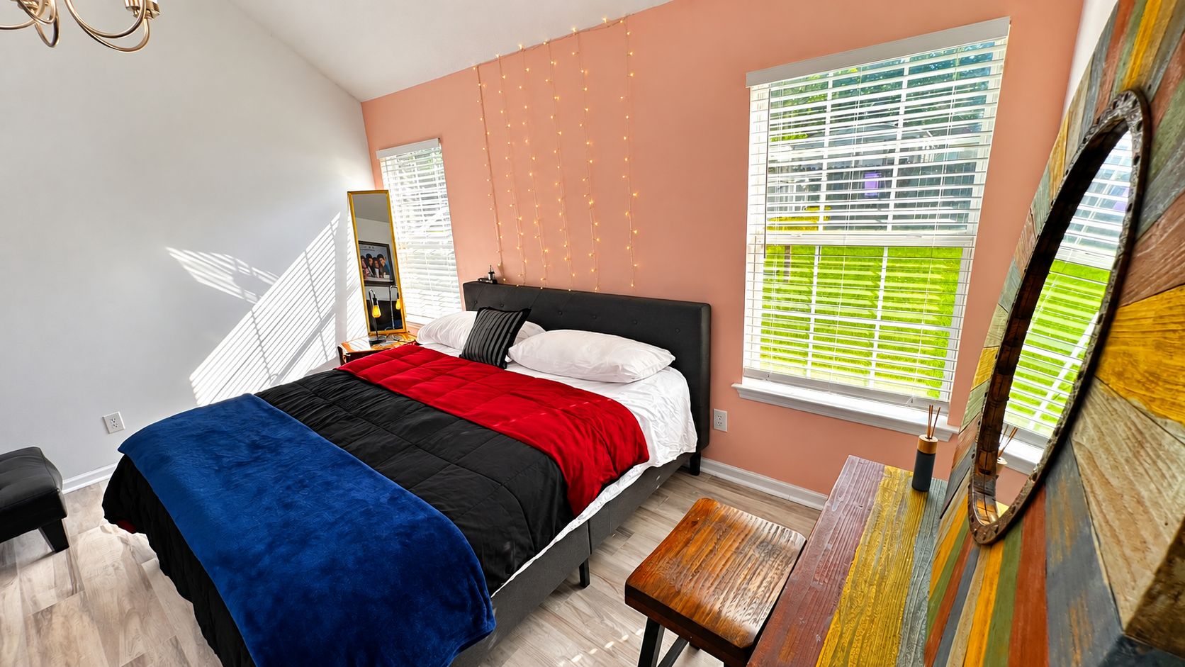 A bedroom with a bed, bedside table, and a window with blinds.