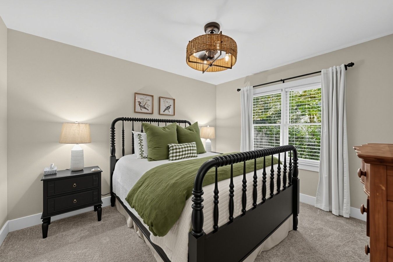 Une chambre à coucher comprenant un lit, des tables de chevet, une lampe, une fenêtre avec des rideaux et un luminaire au plafond.