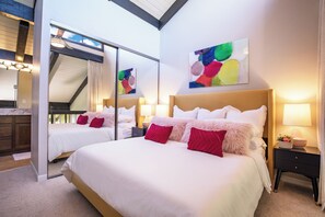 Ein Hotelzimmer mit einem großen Bett, zwei Nachttischen, einem Spiegel und einer Decke mit Oberlichtern.