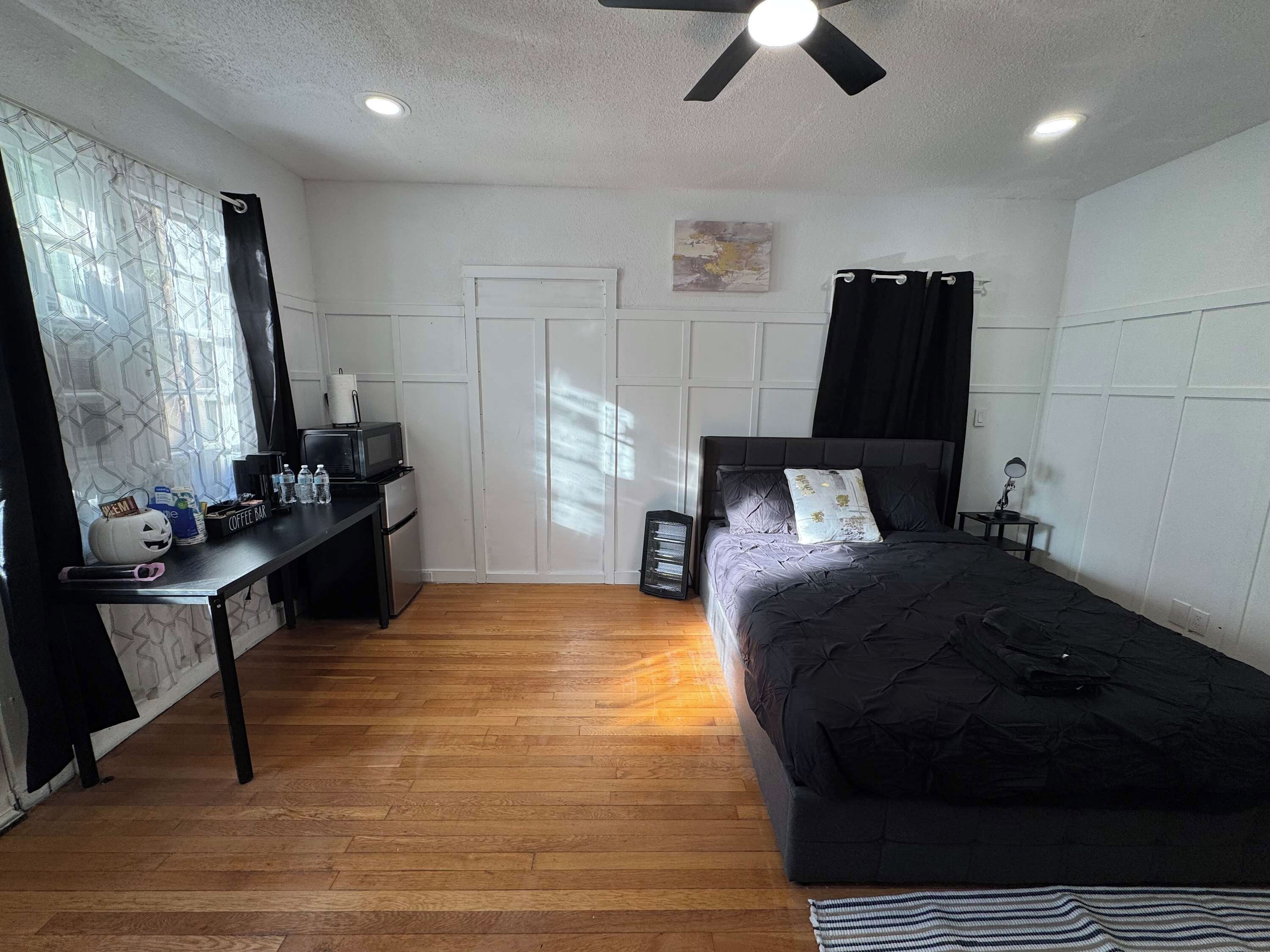 Une chambre comprenant un lit, un bureau, un coin café et une armoire.