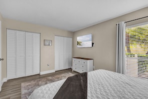 A bedroom with a bed, a dresser, a closet, and a window with blinds. - Beachside Bliss | 1BR | Pool & Patio (Sarasota)