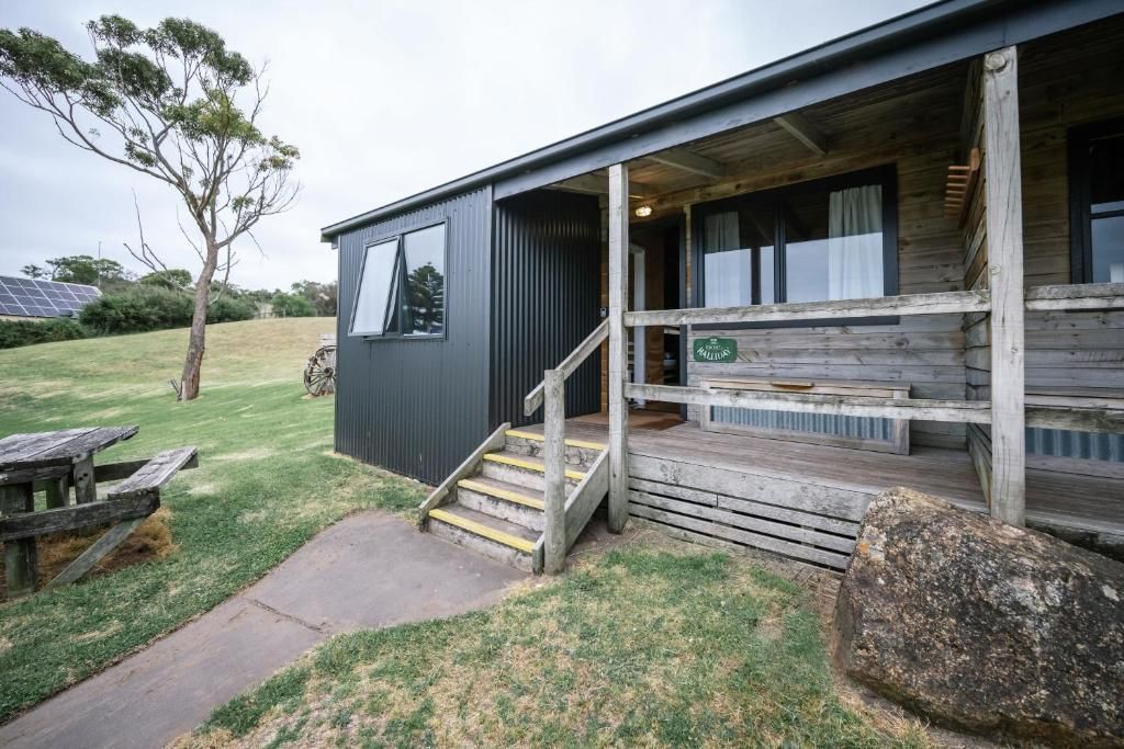 A modern building with a wooden deck and a staircase leading to a covered porch.