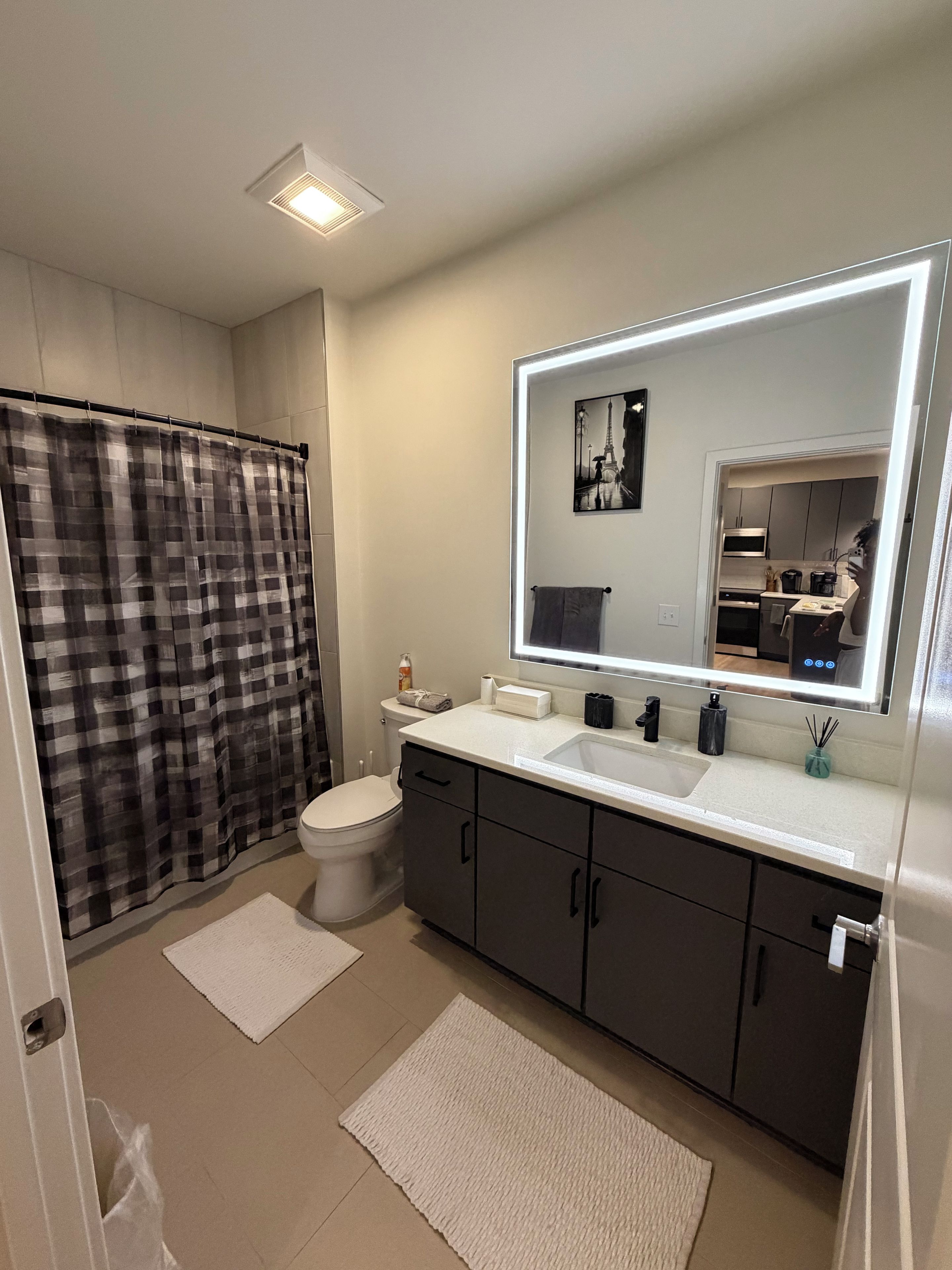 Ein modernes Badezimmer mit Toilette, Waschbecken und Duschvorhang.