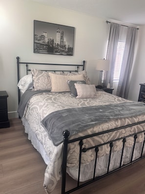 Een bed met een beddengoed met een patroon, een hoofdbord en een kussen met een bloemenprint.