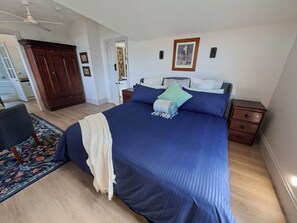 Une chambre à coucher avec un grand lit, une table de chevet, une commode et une chaise.
