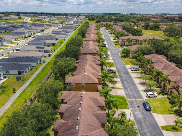 Zona residencial con casas alineadas a lo largo de una calle central, rodeada de vegetación y árboles.