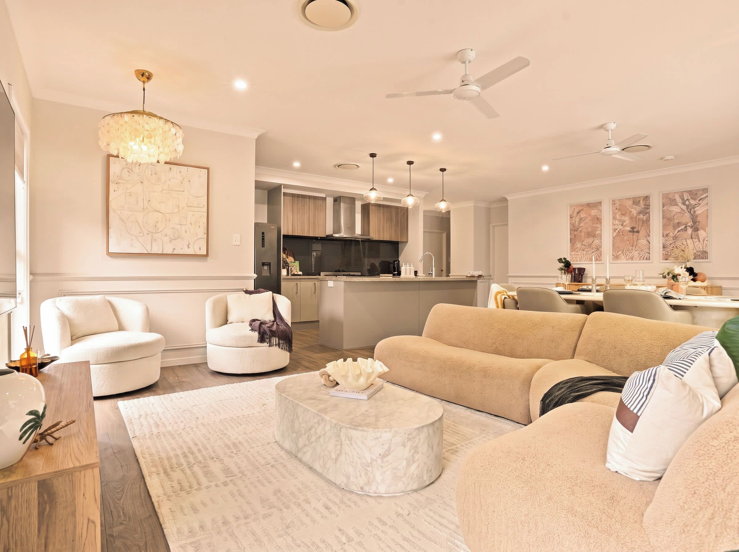 Open-plan living area with curved sofa and 85 inch Smart TV, opening to the garden. House is 18 km to Brisbane CBD, The Garden House