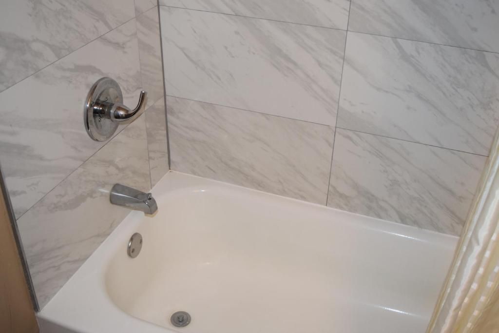 Un baño con bañera, ducha y retrete.