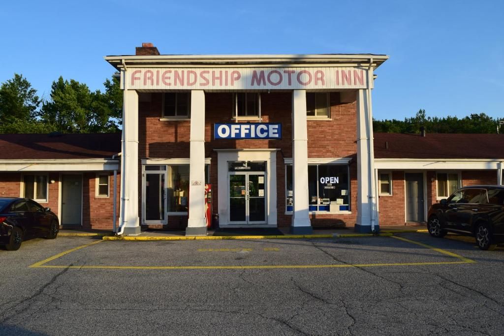 Un edificio con un letrero que dice 'Friendship Motor Inn' y un cartel de 'Oficina' sobre la entrada.