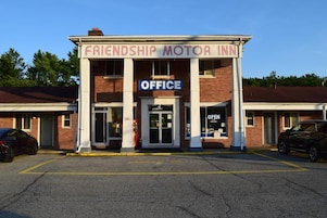 Un edificio con un letrero que dice 'Friendship Motor Inn' y un cartel de 'Oficina' sobre la entrada.