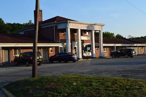 A building with a sign that reads 'FRIENDSHIP MOTOR INN.' There are cars parked in front, and the building has a brick facade with a flat roof.