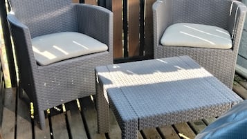 A patio area with wicker furniture, including two chairs and a small table.