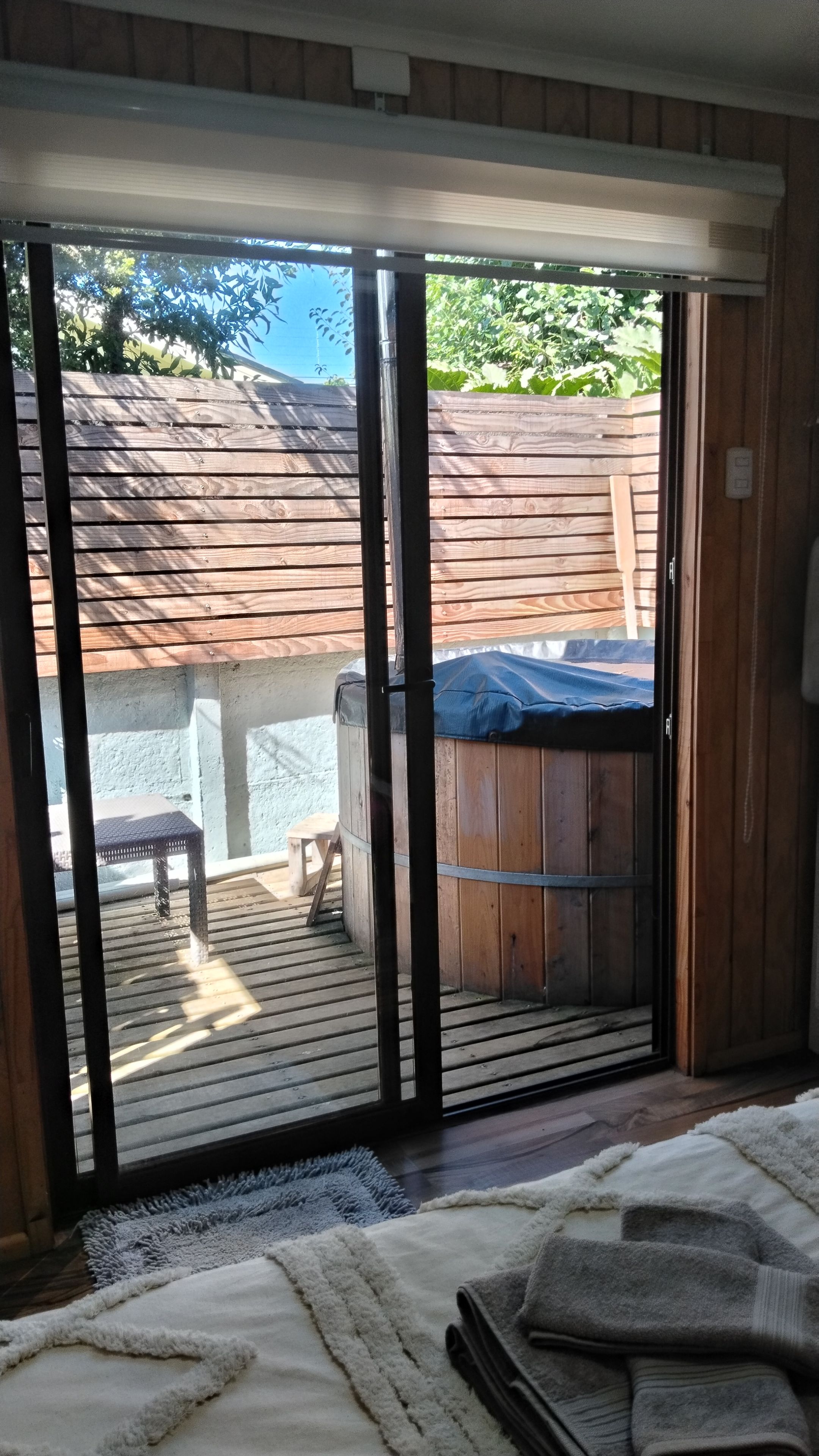 Quarto com porta de vidro deslizante que dá para um pátio externo.