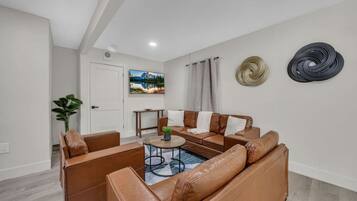 A modern living room with leather sofas, a coffee table, and a painting on the wall.