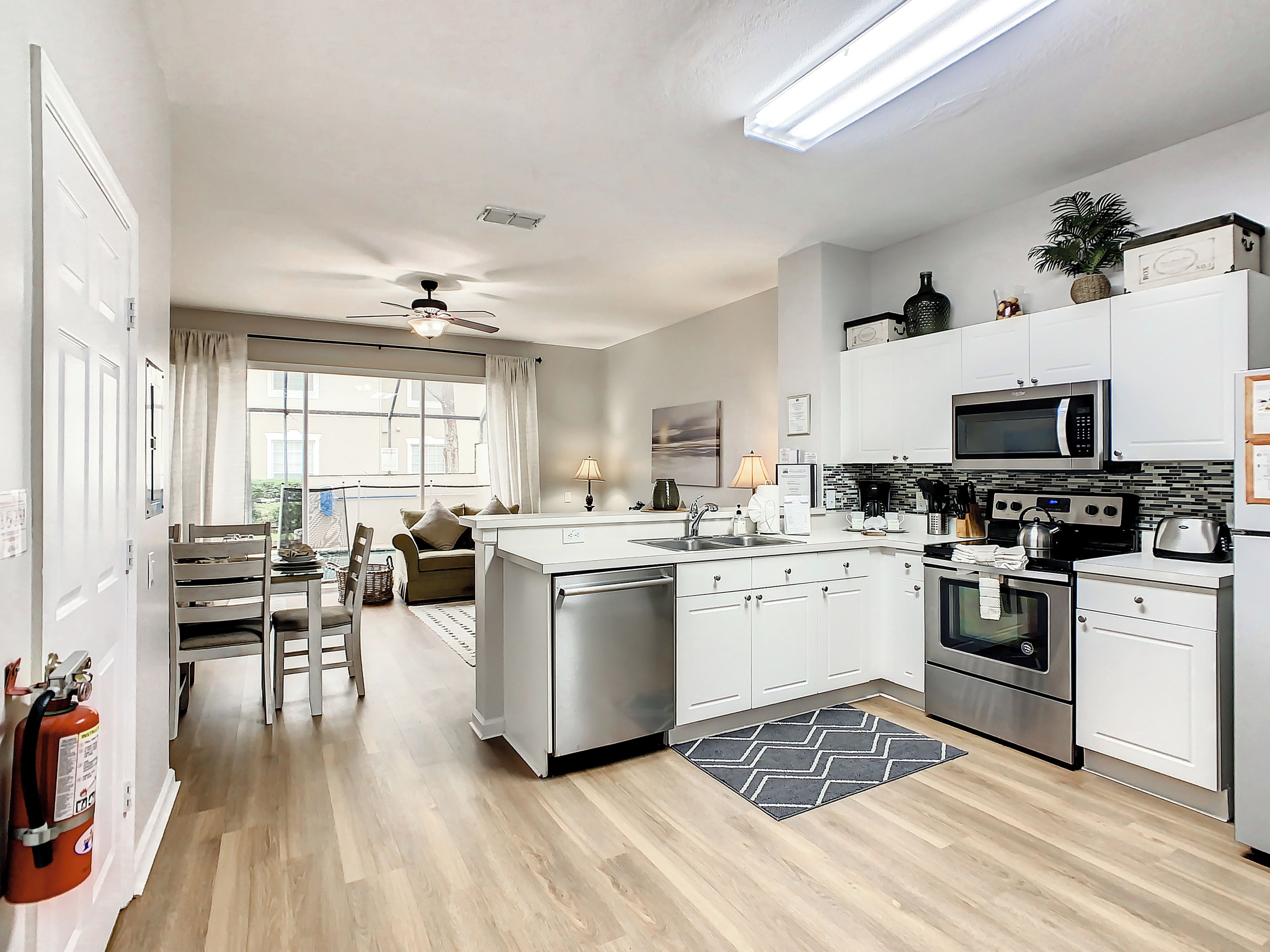 A modern kitchen with white cabinets, stainless steel appliances, and a central island.