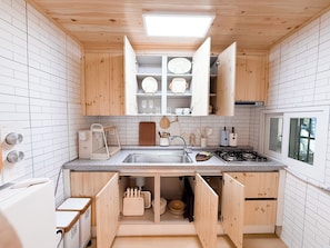 A compact kitchen with wooden cabinets, a built-in sink, and a window.