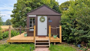Een klein houten gebouw met een witte deur, een bord waarop 'The Railway Retreats' staat en een krans op de deur.