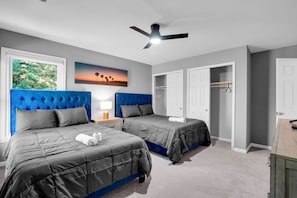 A bedroom with two beds, a ceiling fan, a painting, and a closet. - Elegant living at its finest in Ashburn (Ashburn)