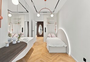 Uma casa de banho moderna com uma toucador curvo, um espelho grande e chão de madeira.