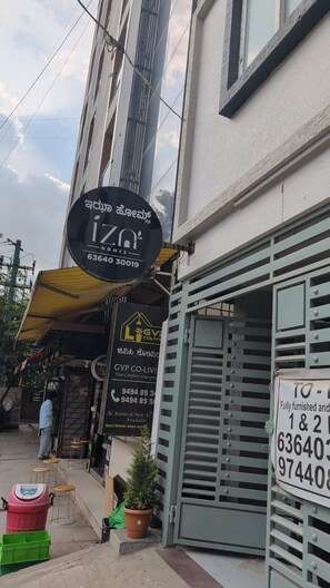 Un edificio con un cartel que indica 'IZNT HOMES' y un número de contacto.